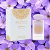A perfume bottle and its box are displayed against a backdrop of purple flowers. Anteprima dell’immagine prodotto