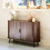 A wooden sideboard with two doors, decorated with vases and a lamp, placed in a room with a window in the background. Anteprima dell’immagine prodotto