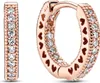 A pair of rose gold hoop earrings with clear stones and heart cutouts. Produktbild-Vorschau