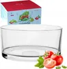A glass salad bowl with tomatoes and basil in front of it, and a product box in the background. Podgląd zdjęcia produktu