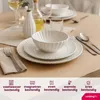 A table setting with white dishes, cutlery, and a bottle of oil. Náhled obrázku produktu