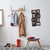 A hallway with a shelf, coats, shoes, and a photo collage on the wall. Náhľad obrázku produktu