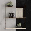 A three-tiered wall shelf with decorative items. Produktbild-Vorschau
