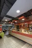 Interior view of a cafe or bakery with a display counter filled with food items. Produktbild-Vorschau