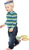 A young child is playing with colorful rings, balancing some on their head and stepping on others. Produktbild-Vorschau