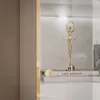 A golden ballerina figurine is displayed on top of books inside a glass-fronted cabinet with LED lighting. Produktbild-Vorschau