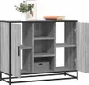 A grey wooden sideboard with black metal legs and frame, shown with its doors open, revealing shelves and a small box. A framed picture and a plant are on top of the sideboard. Produktbild-Vorschau
