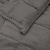 A close-up view of a gray weighted blanket, showing its quilted texture and stitching. Podgląd zdjęcia produktu