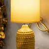 A close-up of a textured yellow table lamp with a yellow lampshade. Anteprima dell’immagine prodotto