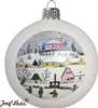 A white Christmas ornament with a painted winter village scene. Náhled obrázku produktu