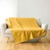A yellow blanket draped over a sofa. Náhled obrázku produktu