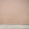 A close-up view of a textured rug with a melange appearance, lying on a wooden floor. Produktbild-Vorschau