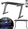 A gaming desk is shown in two different configurations and settings. The top image shows the desk from a front-diagonal angle against a white background. The bottom left image shows the desk set up in a room with a city view at night, featuring a computer  Produktbild-Vorschau