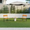 Two chairs and a table are set up on a grassy lawn in front of a white fence and a large umbrella. Produktbild-Vorschau
