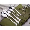 A set of silverware laid out on a green cloth, with a beaded necklace draped nearby. Voir les images du produit