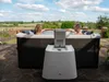 A couple relaxing in a hot tub outdoors on a sunny day. Produktbild-Vorschau