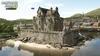 A castle on a small island in the water, with a town in the background. Produktbild-Vorschau