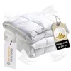 A stack of white duvets with feathers floating around them. Produktbild-Vorschau