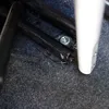 A close-up view of a car's floor mount for a tablet or phone holder, showing a screw and part of the holder mechanism. Produktbild-Vorschau
