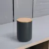 A dark gray ceramic storage jar with a light wood lid sits on a light gray surface. Produktbild-Vorschau