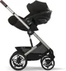 A black Cybex baby car seat attached to a stroller frame, shown from the side against a white background. Podgląd zdjęcia produktu