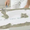 A person is applying mortar to a white surface with a trowel. Produktbild-Vorschau