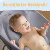 A baby is happily taking a bath in a gray baby bathtub with a support seat. Produktbild-Vorschau