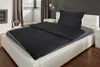 A neatly made bed with black Seersucker bedding in a bedroom setting. Produktbild-Vorschau