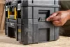 A hand is shown interacting with a stack of black and yellow toolboxes. Voir les images du produit