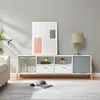 A modern living room scene featuring a white and gray media console with various decorative items and a framed artwork on the wall. Náhľad obrázku produktu