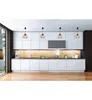A modern kitchen with white cabinets, wooden backsplash, and pendant lights. Náhľad obrázku produktu