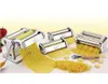 A set of chrome pasta machines with various attachments and freshly made pasta laid out on a table. There are also some red bell peppers in the background on the left. Náhled obrázku produktu