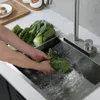 Hands washing green leafy vegetables in a modern kitchen sink with a faucet. Podgląd zdjęcia produktu