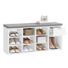 A white shoe storage bench with a gray upholstered top and various shoes stored in its compartments. Produktbild-Vorschau