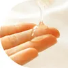A close-up shot of a clear gel being dispensed onto a person's fingers. Podgląd zdjęcia produktu