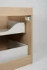 A close-up view of a wooden cabinet with two drawers, showing the drawer slides and a latch mechanism. Podgląd zdjęcia produktu