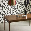 A dining table with decorative items on it, set against a patterned wall. Produktbild-Vorschau