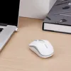 A white wireless mouse sits on a wooden desk next to a laptop and a book. Anteprima dell’immagine prodotto