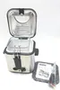 A stainless steel mini deep fryer with its lid open, showing the frying basket inside. Accessories and instructions are placed next to it. Produktbild-Vorschau
