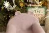 A pink teddy bear-shaped children's chair is placed in front of a decorated Christmas tree. Produktbild-Vorschau