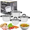 A set of stainless steel pots with glass lids, along with ingredients for cooking, are displayed against a white background. Produktbild-Vorschau