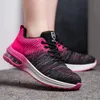 A close-up shot of a pair of pink and black athletic shoes worn by a person. Produktbild-Vorschau