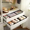 A closet interior with drawers filled with organizers for underwear and accessories, and hats on a shelf. Produktbild-Vorschau