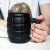 A person's hands are holding a black mug shaped like a grenade. Voir les images du produit