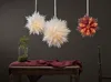 Three paper star lanterns hang above a wooden table with a dark red cloth and a glass vase with a plant. Podgląd zdjęcia produktu