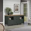 A dark green sideboard with a wooden top is displayed in a living room setting, with plants and decor on top and a framed picture on the wall. Podgląd zdjęcia produktu