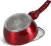 The bottom of a red saucepan is shown, resting on a white surface. A silver lid is partially visible beneath the saucepan. Podgląd zdjęcia produktu