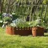 A garden scene with a rustic metal border around flower beds. Produktbild-Vorschau