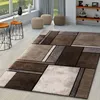 A modern living room with a geometric rug, side tables, and ottomans. Produktbild-Vorschau