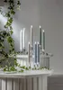 A collection of LED candles in various colors displayed on a tiered white stand, with ivy vines draped around the scene. Podgląd zdjęcia produktu